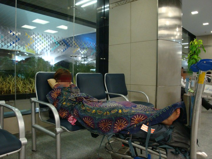 ムンバイの空港のベンチで器用に寝る日本人の女の子